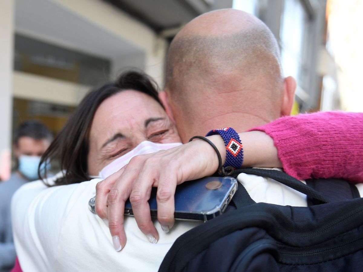 Foto: Dos personas agraciadas con el cuarto premio se abrazan. (EFE/Eloy Alonso)