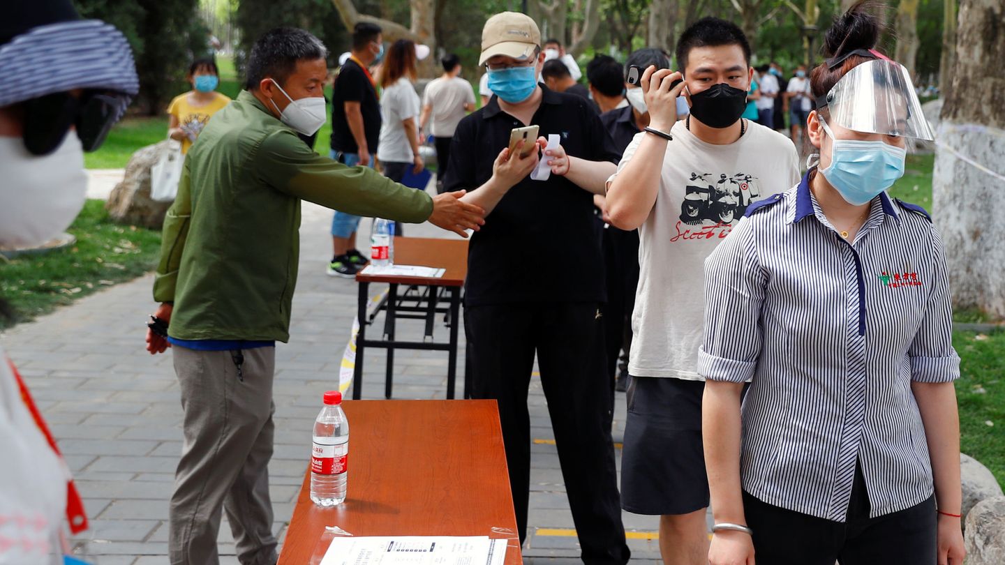 Un grupo de personas con mascarillas y guardando la distancia de seguridad. (Reuters)