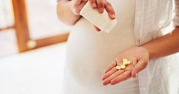 Foto: Una mujer embarazada tomando pastillas (Foto: iStock)