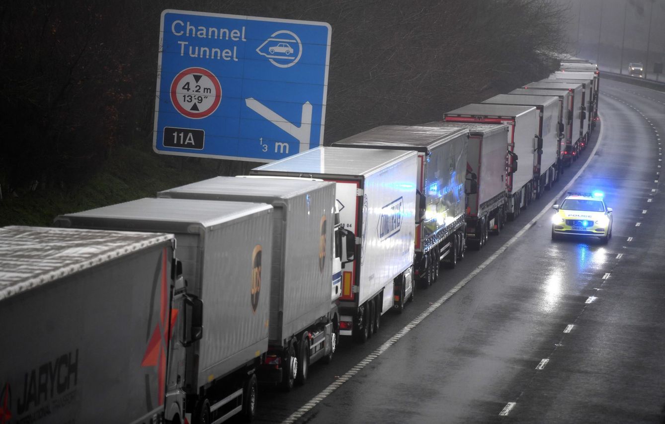 Un coche de policía pasa junto a una larga cola de camiones que permanecen atrapados a causa del cierre de la frontera con Reino Unido decretado por Francia. (EFE)