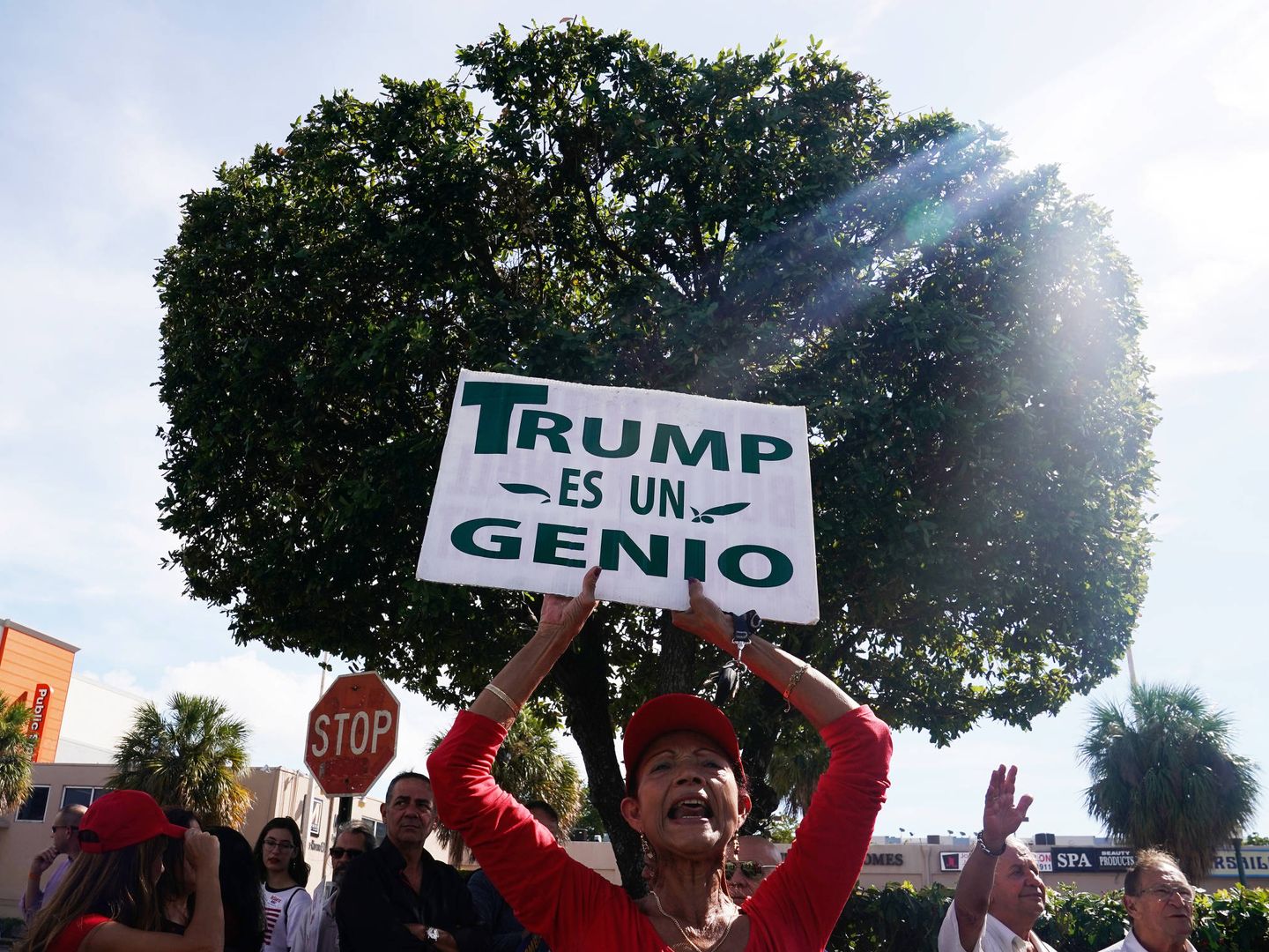 Una votante del candidato Ron DeSantis con un cartel de apoyo a Trump, en Miami, Florida. (Reuters) 