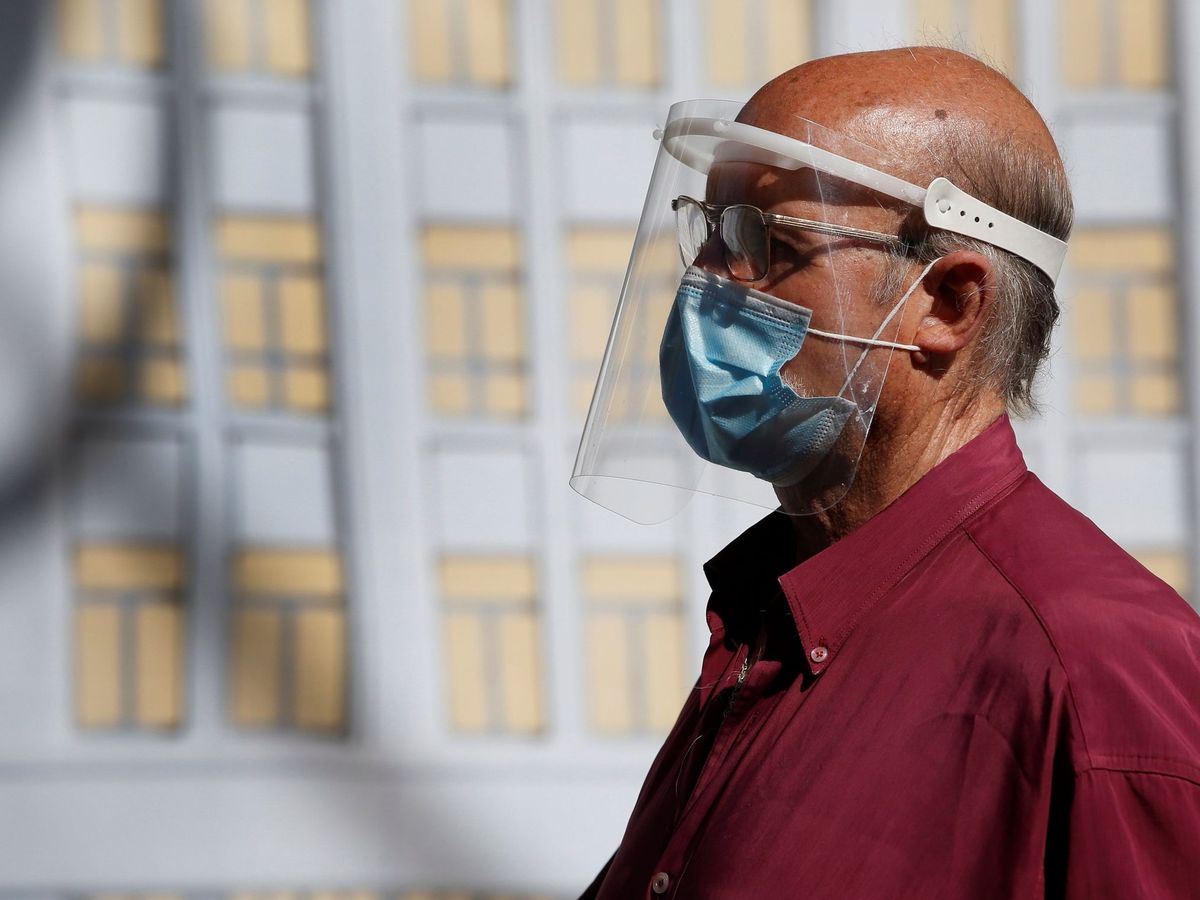 Foto: Un ciudadano con mascarilla y pantalla protectora camina por el centro de Madrid, este miércoles. (EFE)