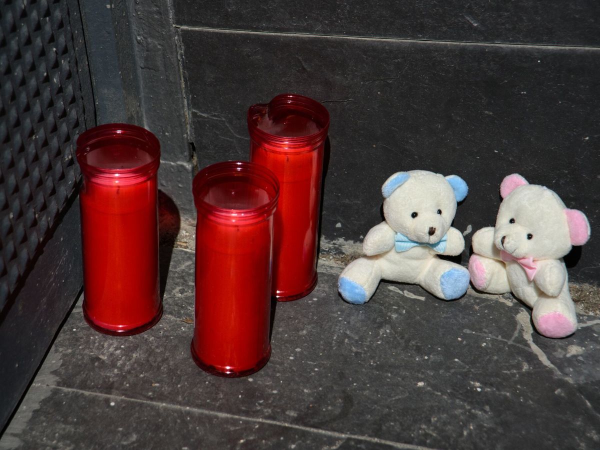 Foto: Tres velas y dos osos de peluche en la puerta del garaje de la vivienda donde un hombre ha matado presuntamente a su mujer y sus dos hijos menores en El Prat de Llobregat. (Europa Press/Alberto Paredes)