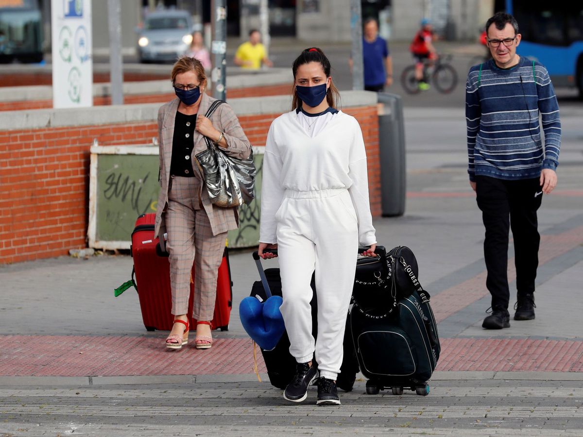 Foto: Viajeros con mascarillas en Atocha, Madrid. (EFE)