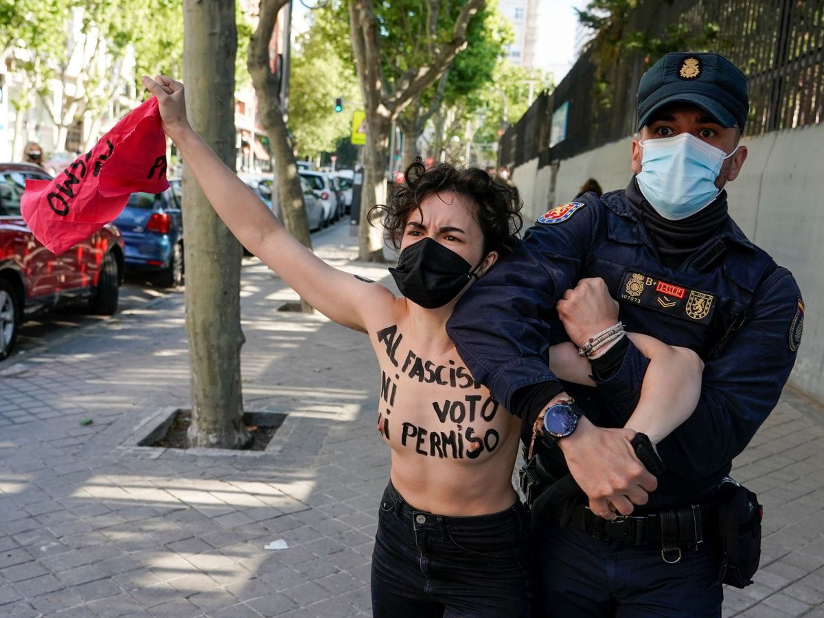 Foto: Un policía retiene a una de las activistas que protestaban. (Reuters)