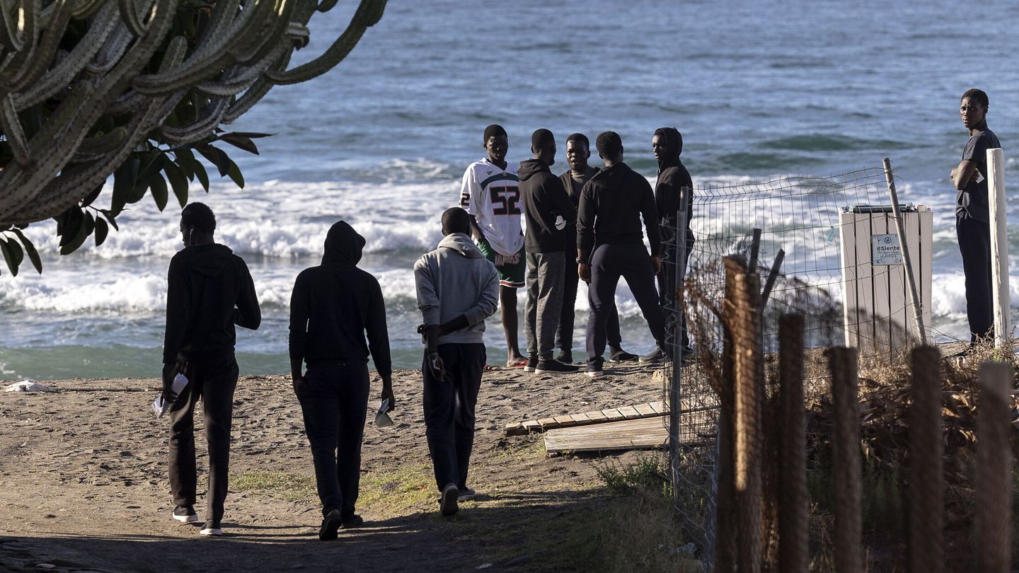 Algunos de los 240 inmigrantes llegados en una playa próxima al hotel en el que han sido alojados. (EFE)