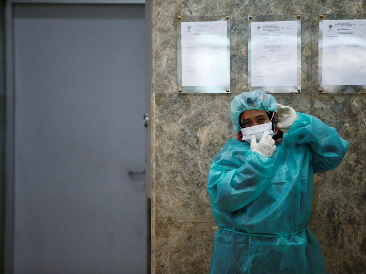 Foto: Un periodista se protege durante una visita al laboratorio de Salud de Indonesia en Jakarta durante el brote de coronavirus (Reuters)