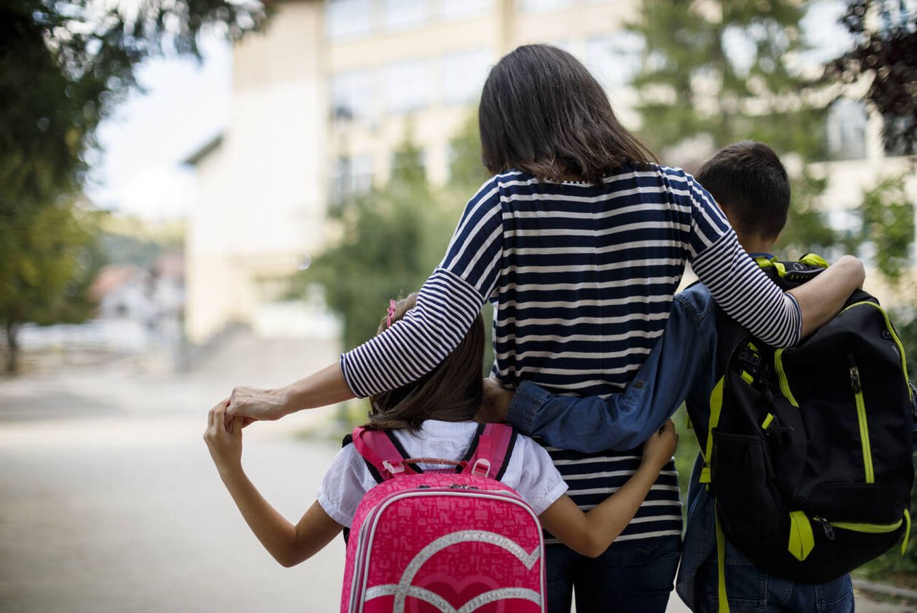 Una madre llevando a sus hijos al colegio (iStock)