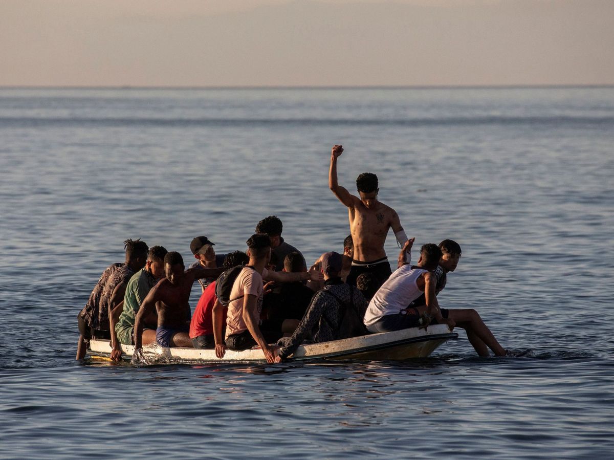Foto: Un grupo de menores intentan cruzar a España a bordo de una barca cerca de la playa ceutí de El Tarajal. (EFE)