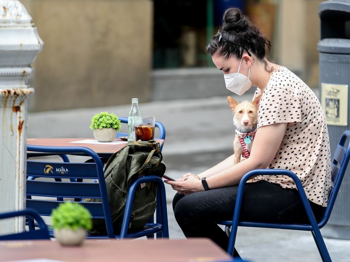 Foto: Una joven toma una consumición protegida con mascarilla este viernes en San Sebastián. (EFE) 