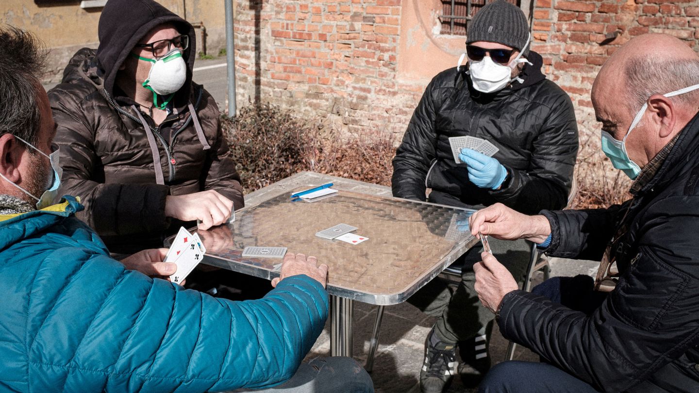 Cuatro hombres juegan a las cartas en San Fiorano, una de las localidades en cuarentena. (Reuters)