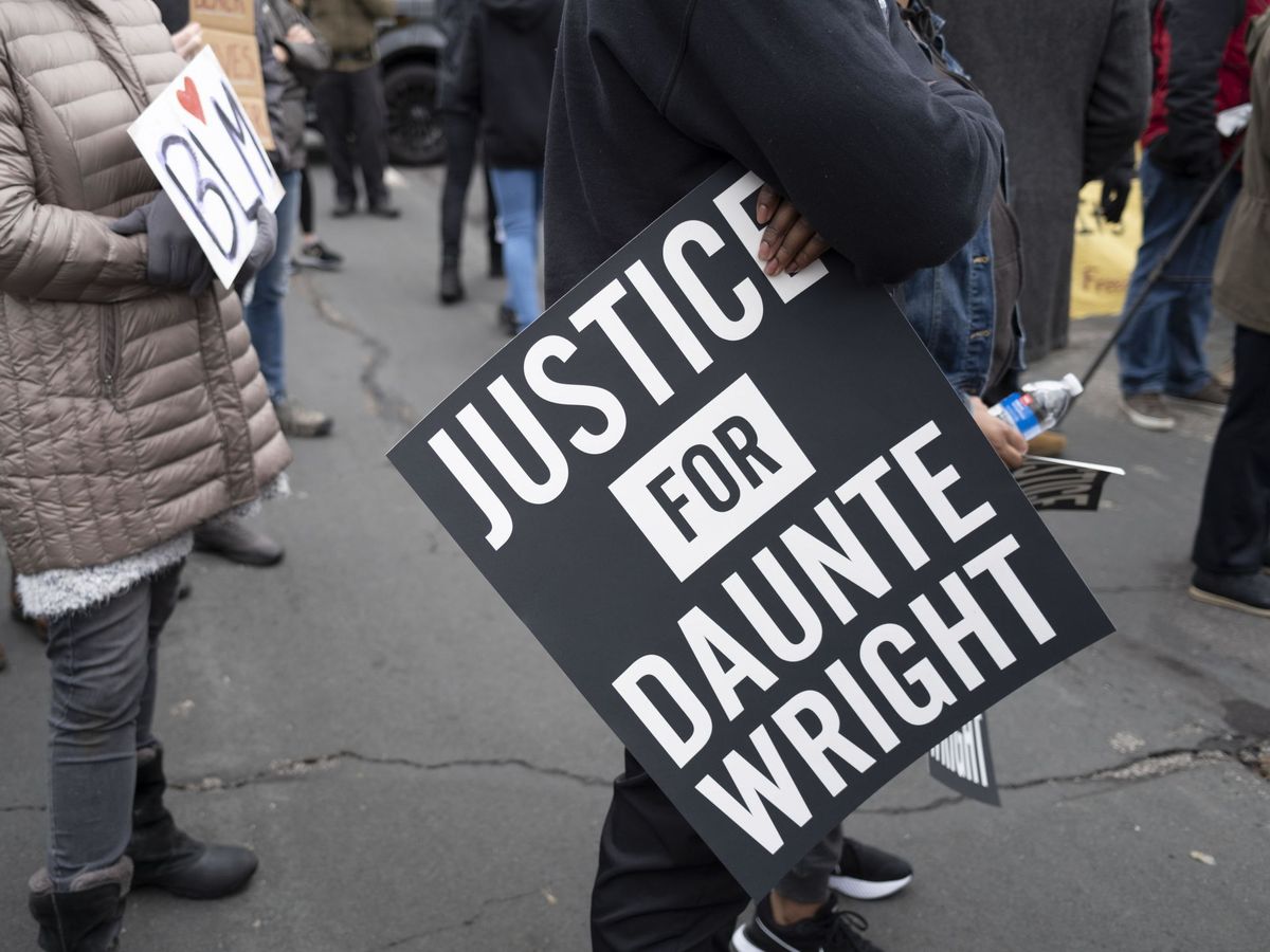 Foto: Un manifestante sostiene un cartel en el que pone "Justicia para Daunte Wright" frente al Departamento de Policía de Brooklyn Center. (EFE) 