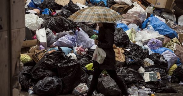 Foto: Una mujer camina junto a la basura acumulada durante la huelga de limpieza en Málaga el pasado año. (EFE)