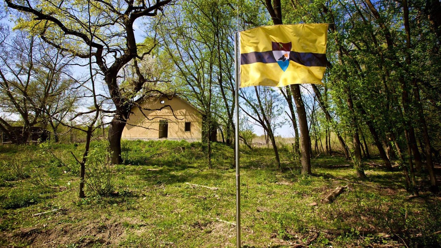 Una cabaña en el centro de Liberland, junto a la bandera del país. (Reuters)