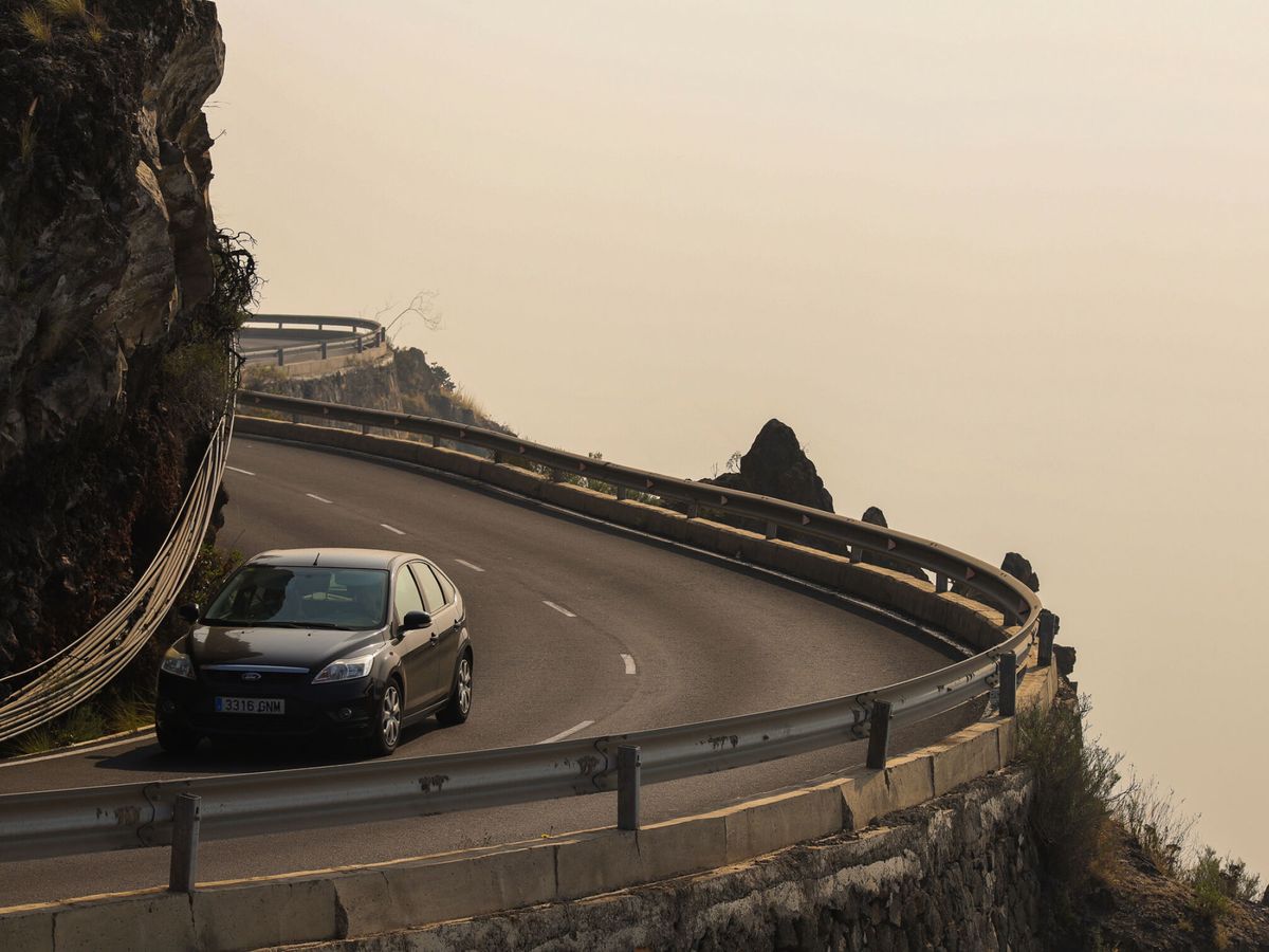Foto: El humo provocado por el incendio, al fondo de una carretera de La Palma. (EFE/Luis G. Morera)