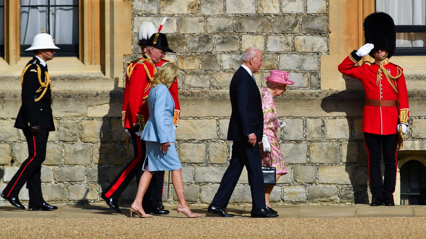 Joe y Jill Biden caminando junto a Isabel II en el castillo de Windsor. (Reuters)