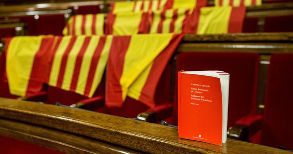 Foto: Aspecto de los escaños del PPC, con banderas de España y de Cataluña y un ejemplar con la Constitución española. (EFE)