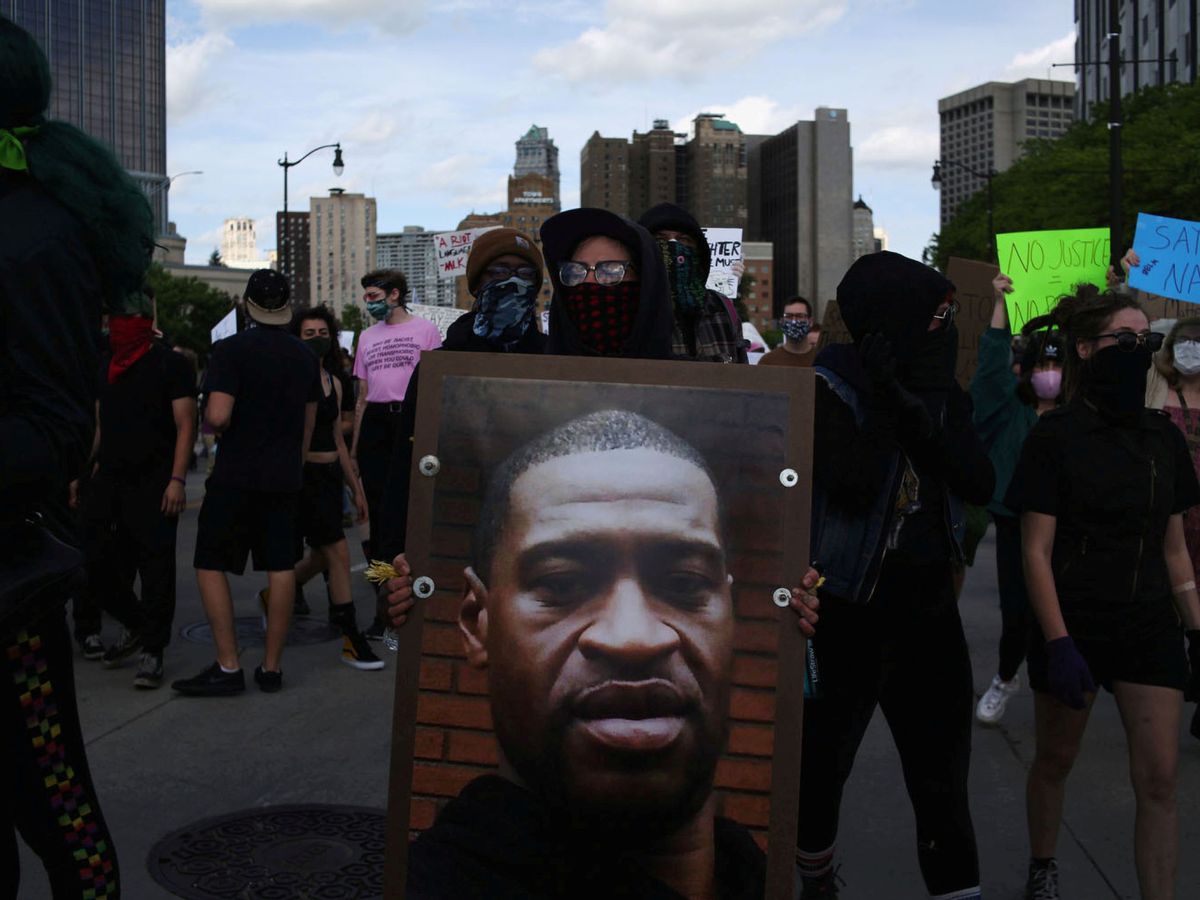 Foto: Un manifestante sostiene una foto de George Floyd durante las protestas en Detroit. (Reuters)