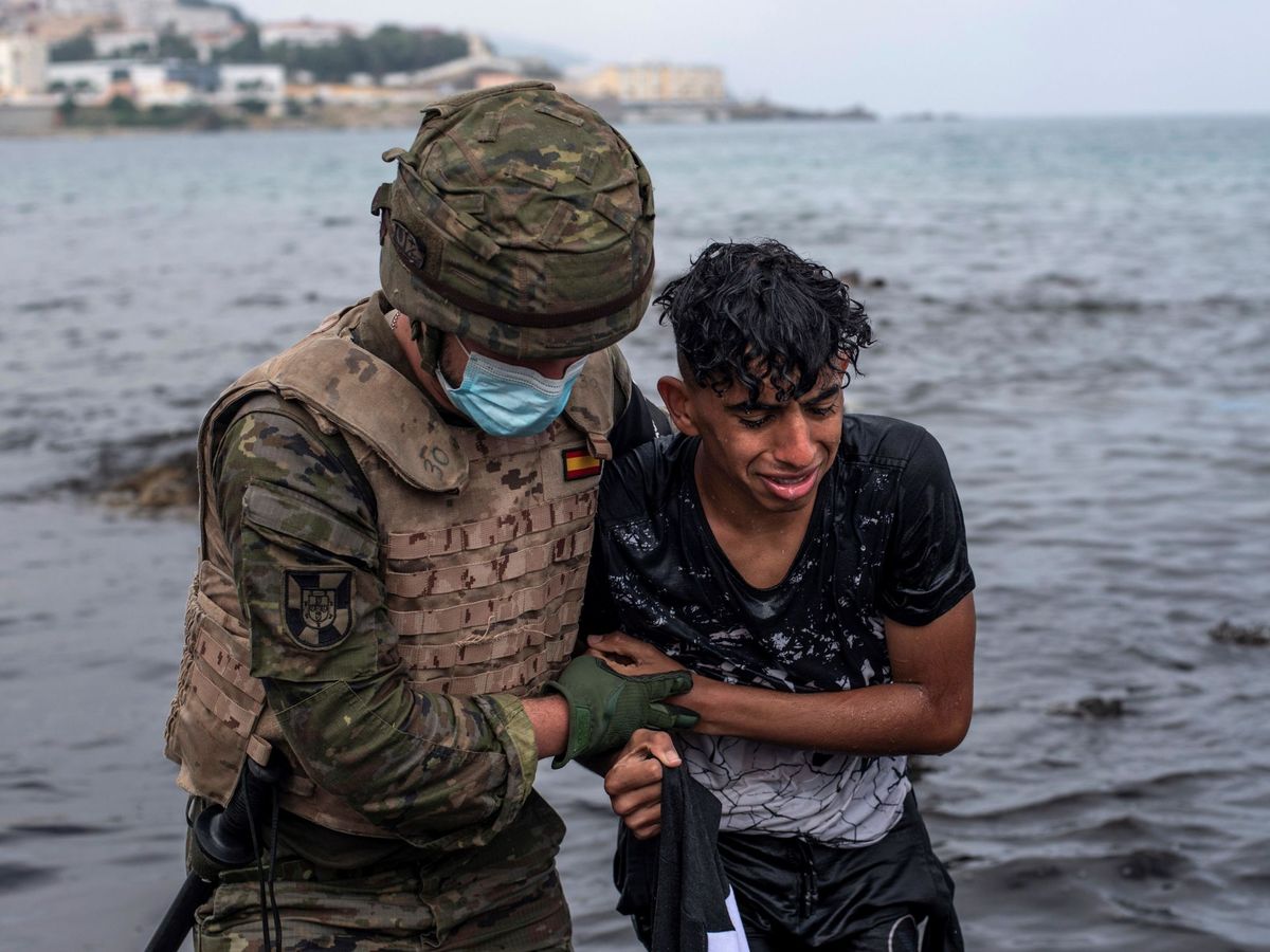 Foto: Un soldado ayuda a un inmigrante a salir del agua. (EFE)