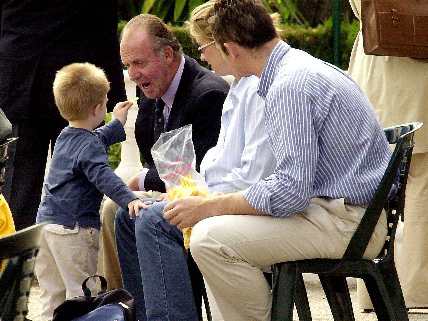 El rey Juan Carlos come una patata que le da su nieto ante la mirada de Iñaki y Cristina. 