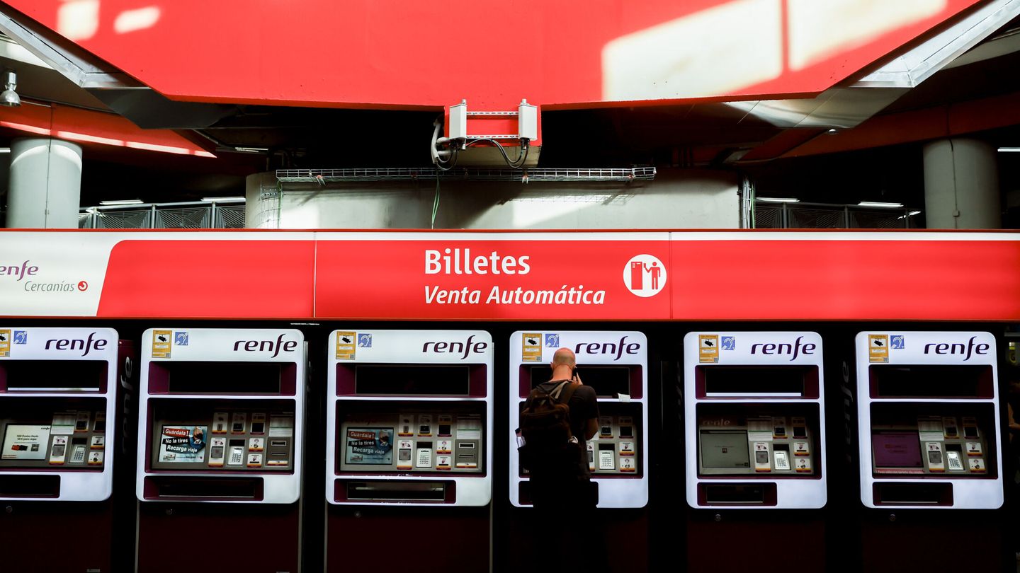 Viajeros gestionan la compra de sus abonos en máquinas expendedoras de billetes en una estación de Cercanías de Madrid. (EFE/Mariscal)