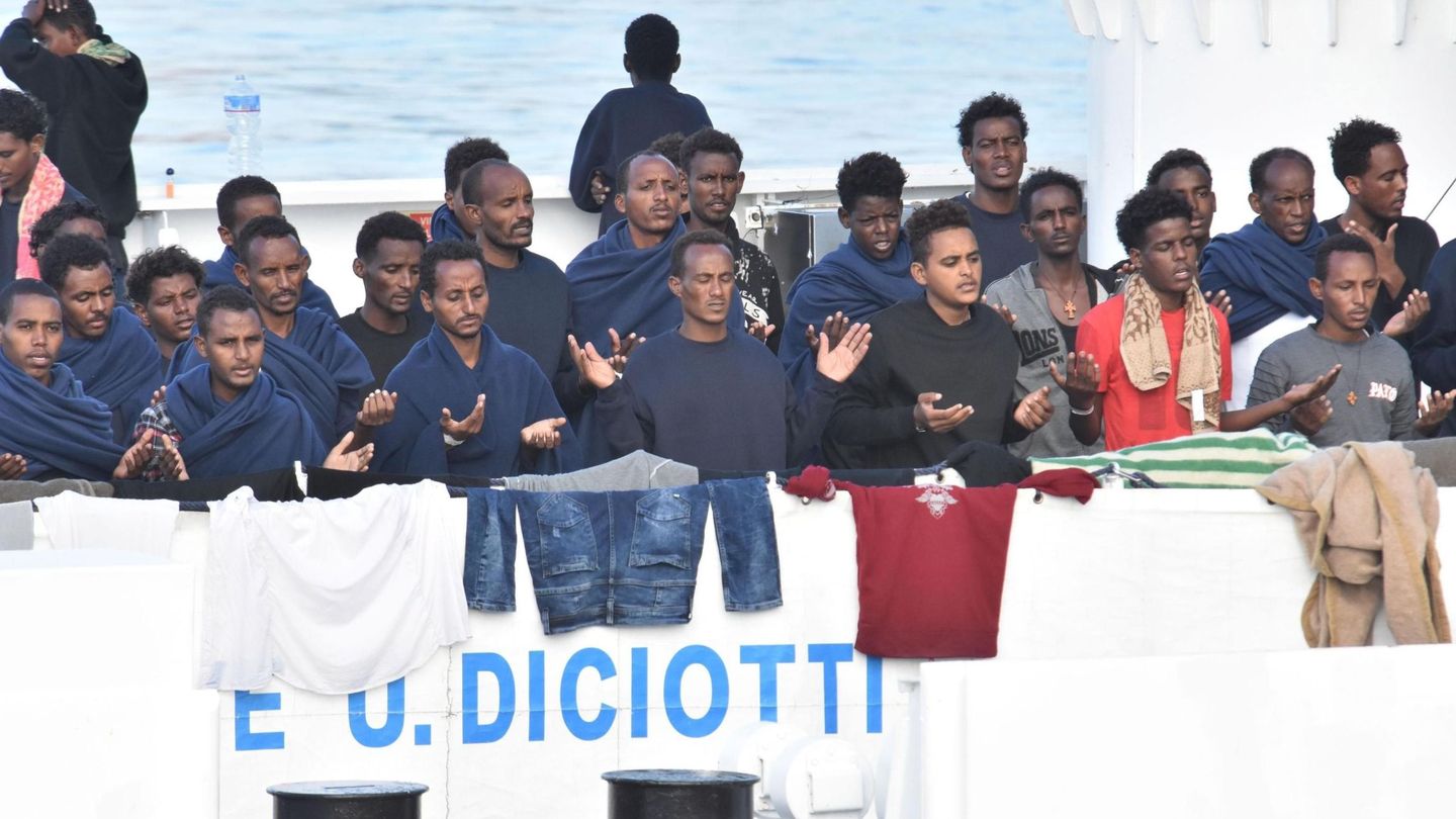 Los migrantes retenidos a bordo del barco militar Diciotti rezan a la espera del desembarco en Catania, el 22 de agosto de 2018. (EFE)