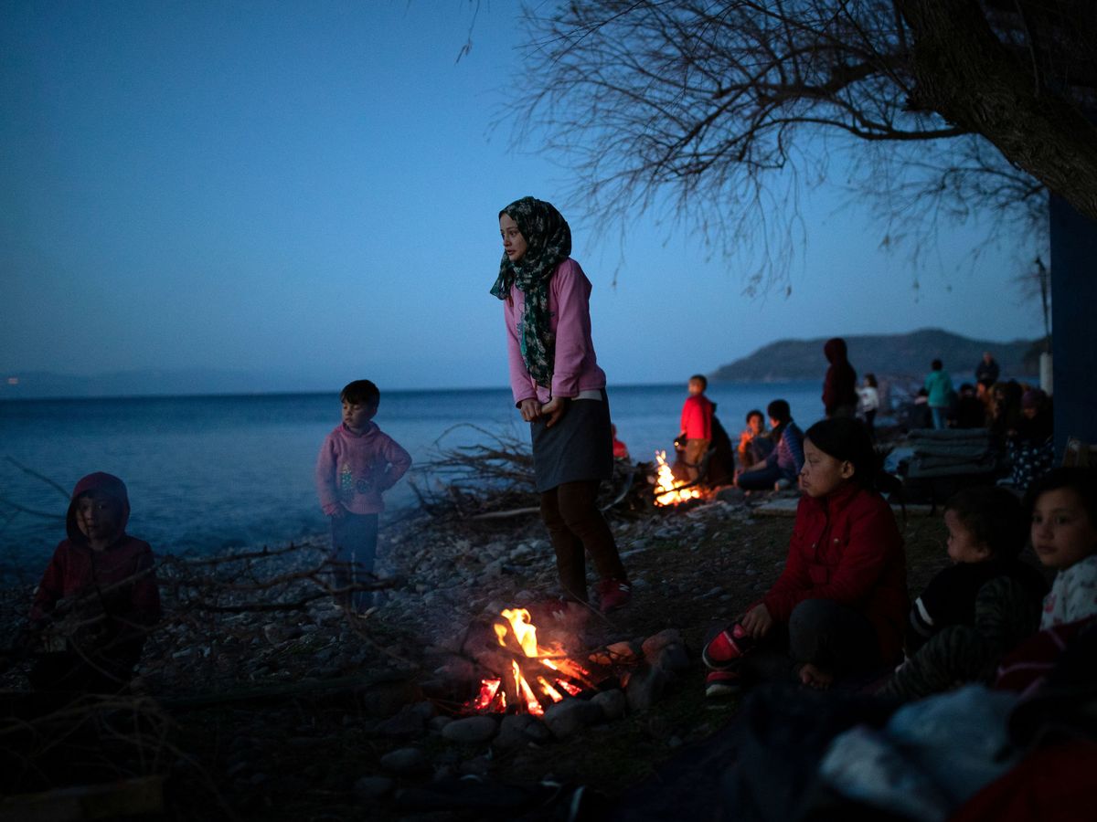 Foto: Los migrantes de Afganistán que llegaron a una playa después de cruzar parte del Mar Egeo desde Turquía a la isla de Lesbos, se calientan junto a una hoguera cerca de la aldea de Skala Sikamias, Grecia (Reuters)