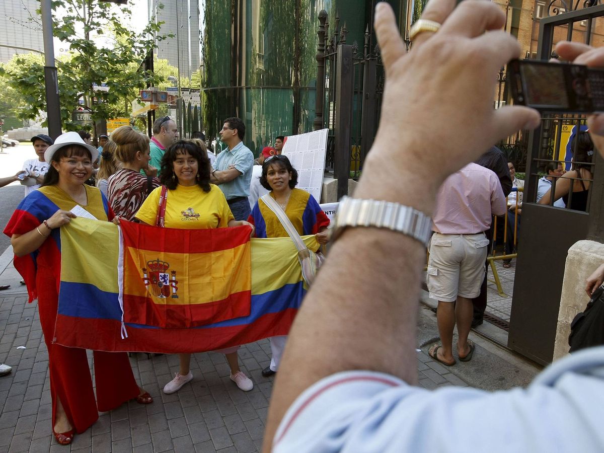 Foto: Ciudadanos colombianos residentes en Madrid se fotografían con banderas de su país y de España ante la embajada. (EFE/Fernando Alvarado)