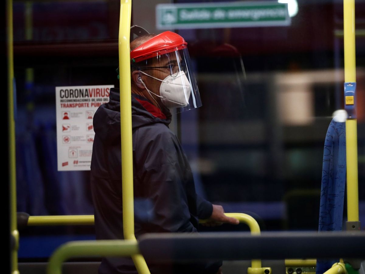 Foto: Un hombre protegido con mascarilla y una pantalla viaja en un autobús. (EFE)
