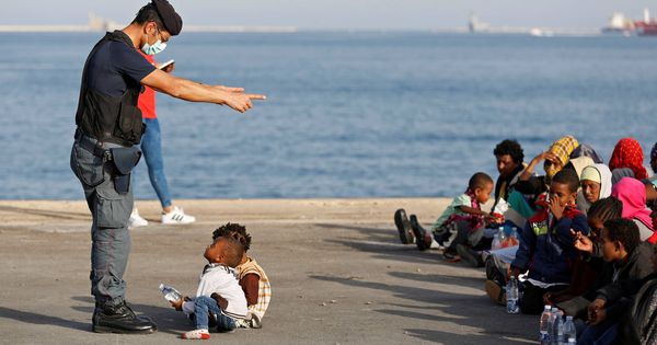 Foto: Un policía italiano habla con menores inmigrantes que acaban de desembarcar en Augusta, Sicilia. (Reuters)