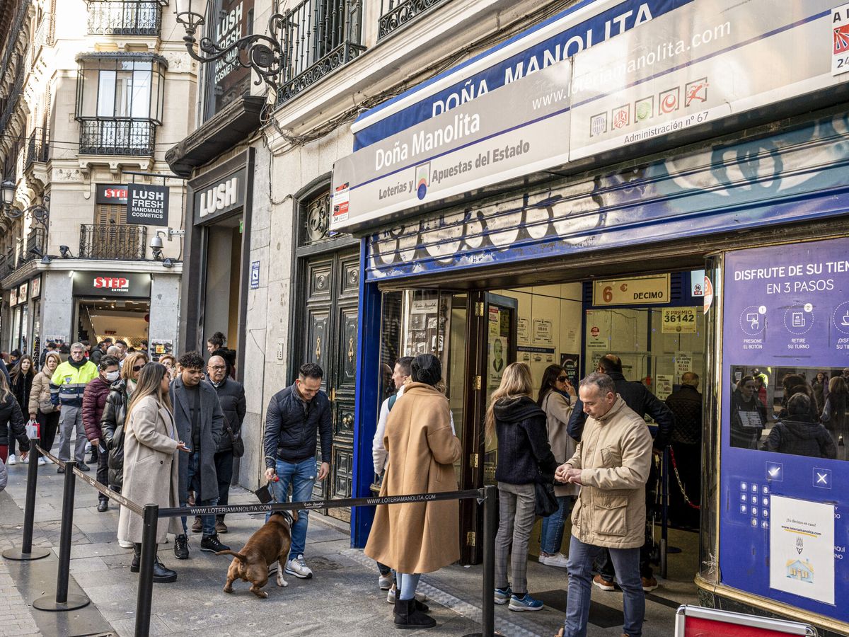Foto: Una larga cola a la puerta de la administración de lotería de Doña Manolita, en Madrid. (EFE/Fernando Villar)