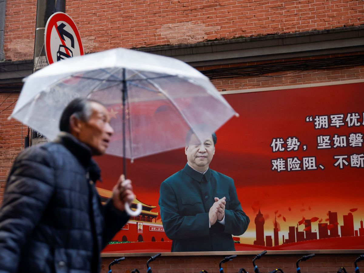 Foto: Un hombre camina frente a un cartel de Xi Jinping. (Reuters)