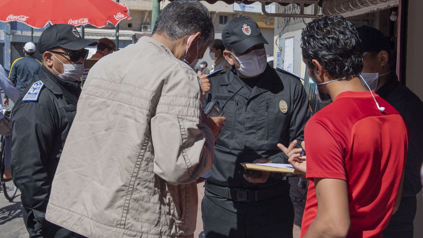 La policía marroquí discute con unos viandantes que se han saltado el toque de queda. (EFE)
