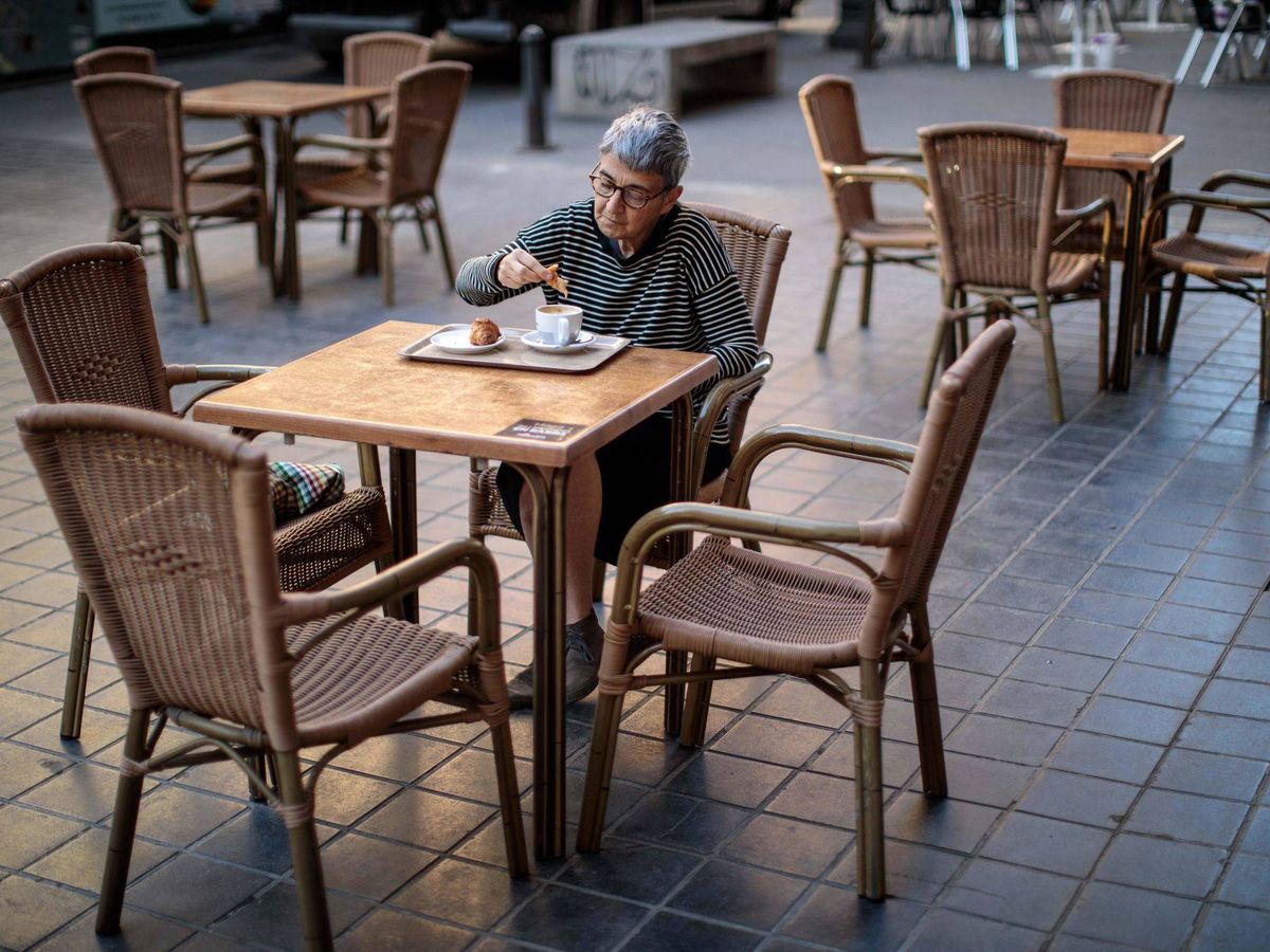 Foto: Una mujer desayuna en la terraza de una cafetería de la estación de Cercanías de Madrid-Atocha. (EFE)