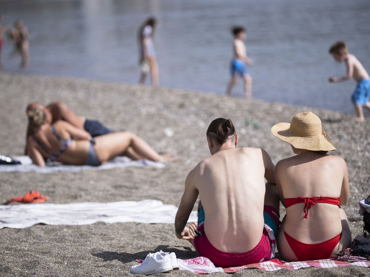 Foto: Unas personas disfrutan del buen tiempo en la playa de la Malagueta en Málaga. (EFE/Jorge Zapata)