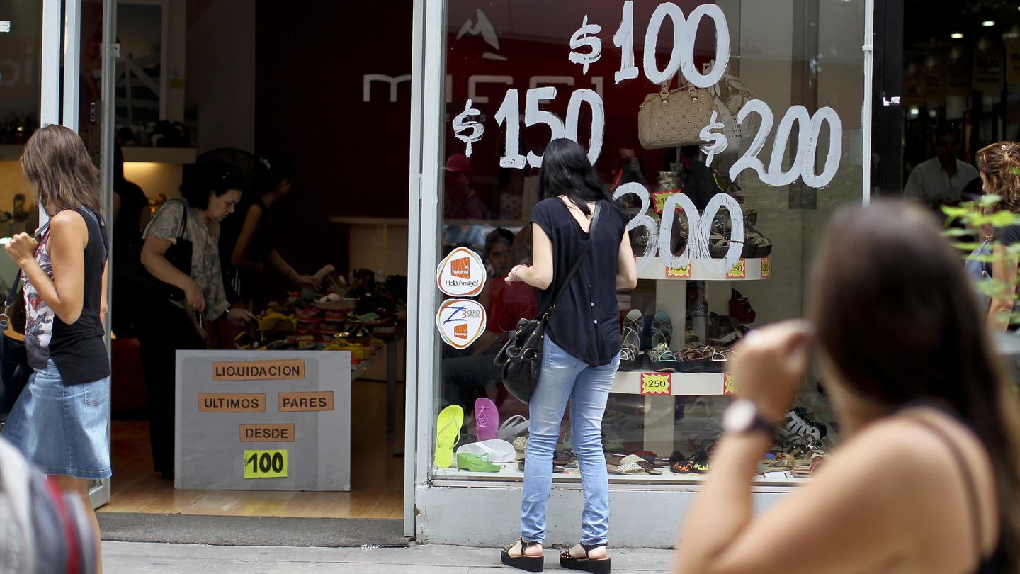 Una mujer observa una vitrina que anuncia ofertas en calzado en Buenos Aires (Argentina). (EFE)