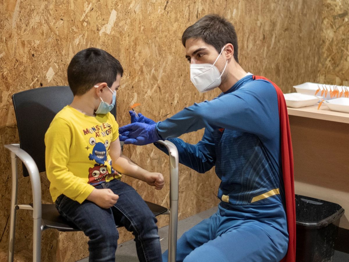 Foto: Un trabajador sanitario vestido de superhéroe antes de vacunar a un niño. (EFE/Brais Lorenzo) 