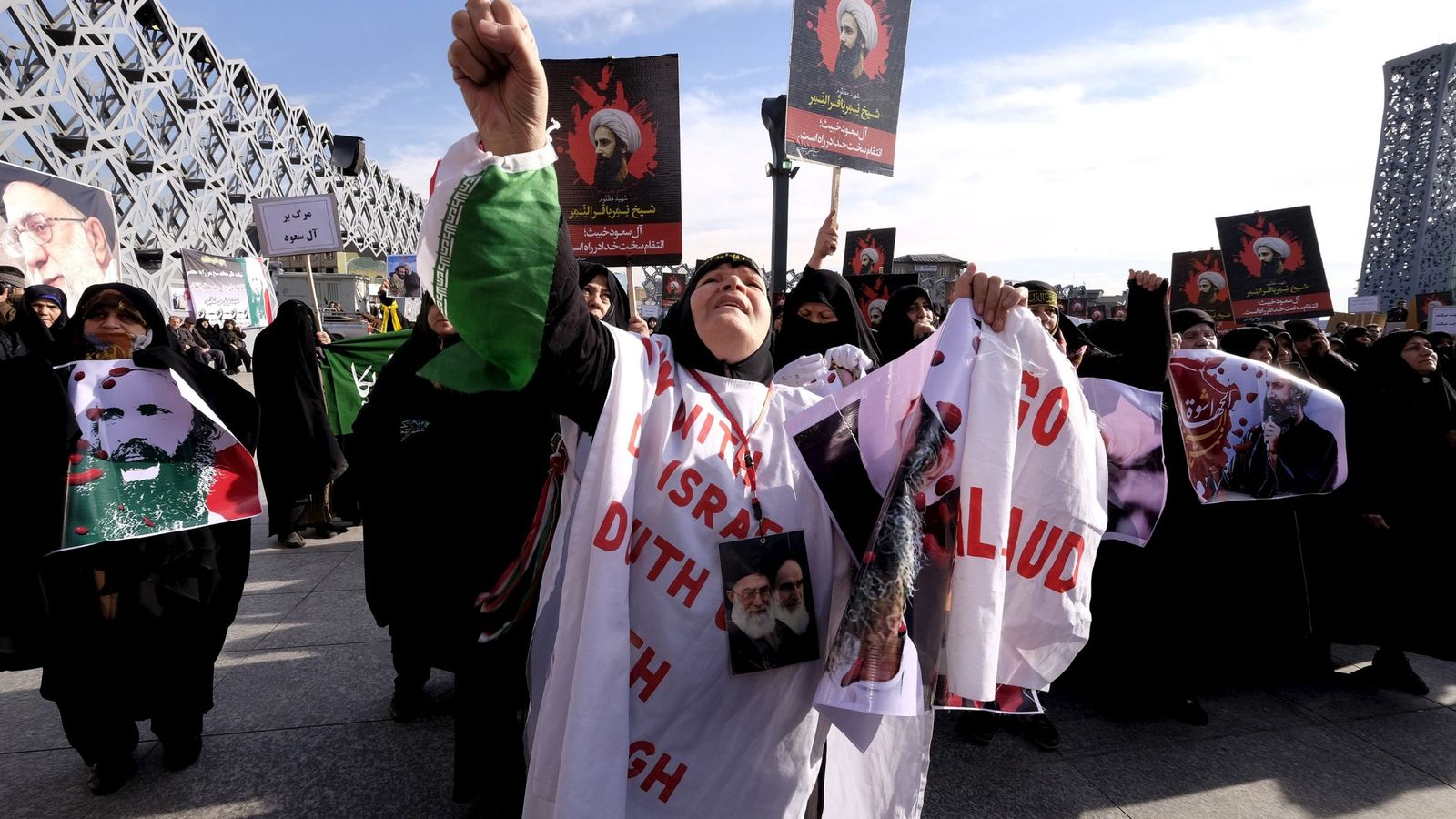 Foto: Una mujer iraní con fotografías del clérigo Nimr Baqir al Nimr durante una protesta en Teherán tras su ejecución, el 4 de enero de 2016. (Reuters).