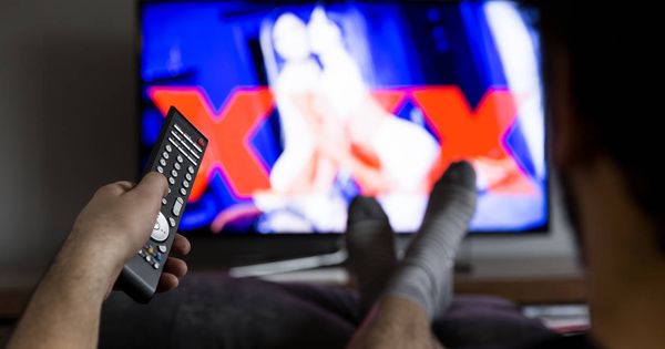 Foto: Hombre mira pornografía en la televisión. (iStock)