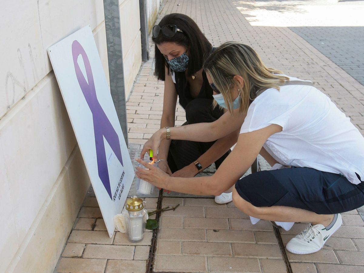 Foto: Dos mujeres encienden velas durante la concentración por el asesinato machista en Alovera (Guadalajara), este domingo. (EFE)