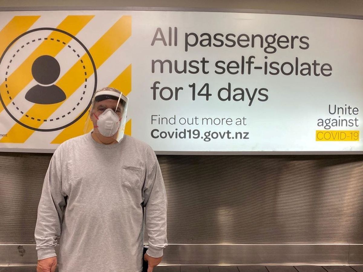Foto: El productor estadounidense Jon Landau posa frente a un letrero que dice "Todos los pasajeros deben aislarse durante 14 días", mientras llegan al Aeropuerto Internacional de Wellington (Reuters)