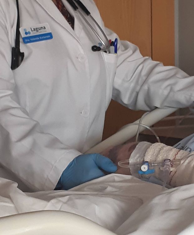 Foto: Un facultativo del Hospital Centro de Cuidados Laguna sujeta la mano de un enfermo terminal.