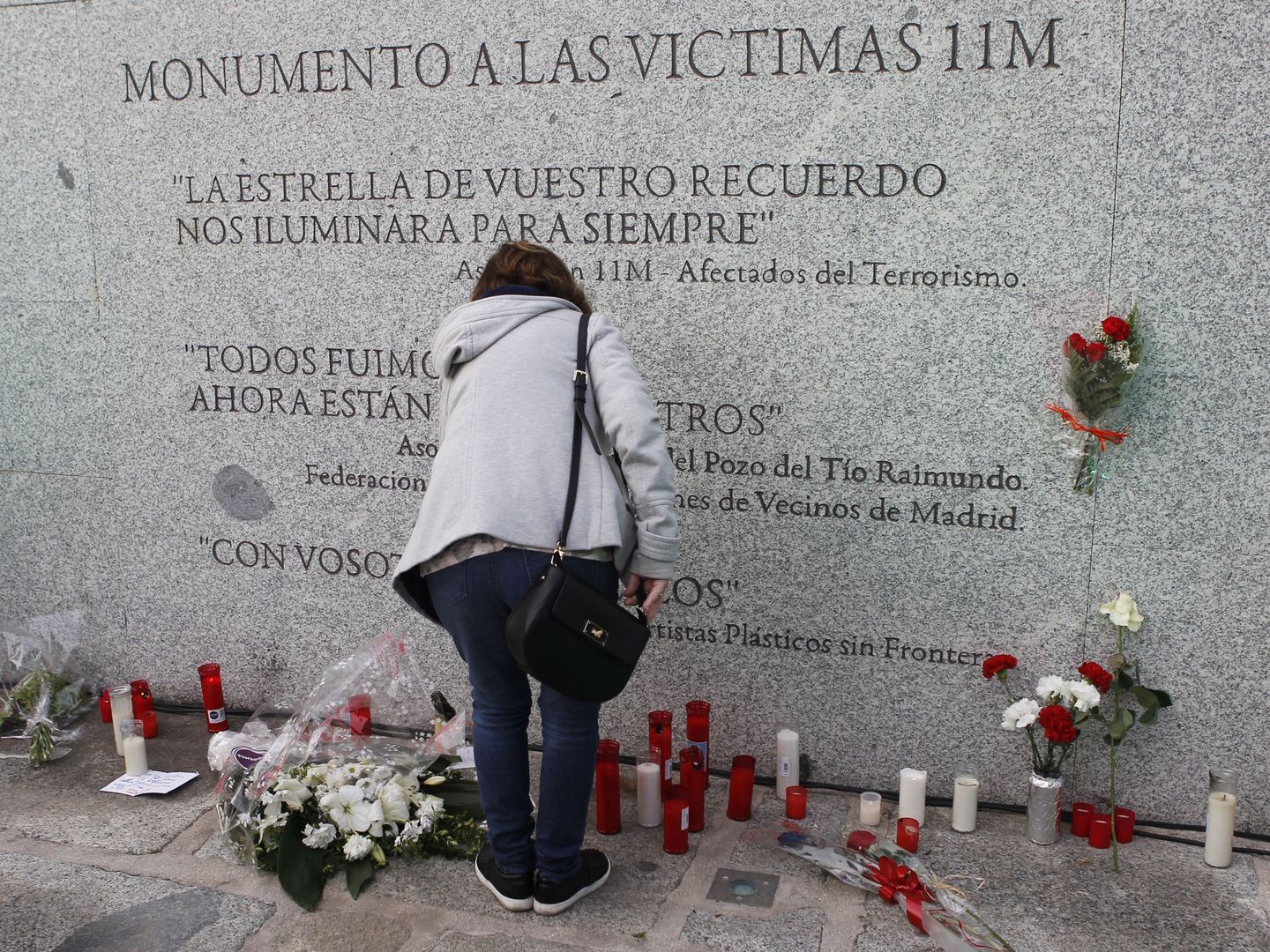 Flores y velas junto al monumento a las víctimas de los atentados del 11M en la estación de El Pozo. EFE