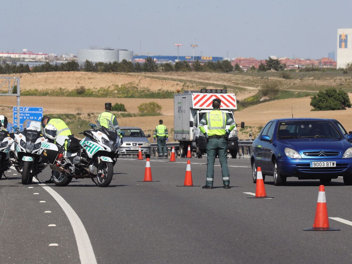 Foto: Agentes de la Guardia Civil realizan un control de vehículos en la autopista A-5 en su salida de Madrid. (EFE)