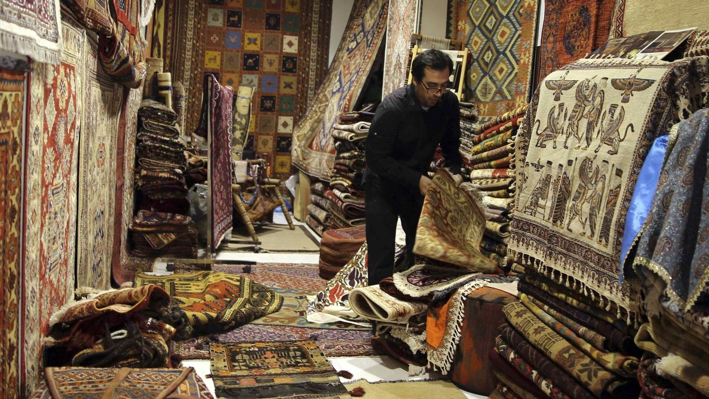 Un vendedor entre alfombras iraníes en su tienda en el viejo mercado de Dubai (Reuters).