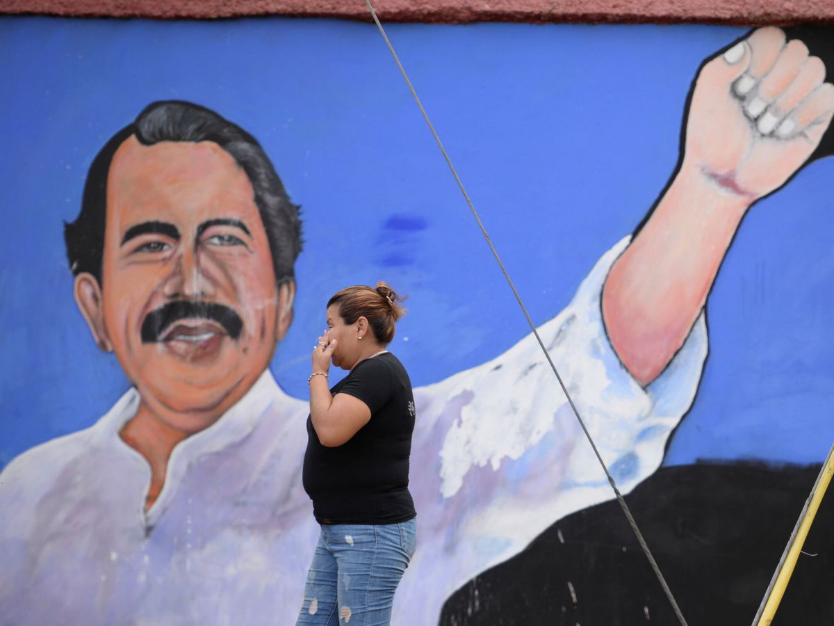Foto: Una mujer camina frente a un mural de Daniel Ortega en Managua. (Reuters)