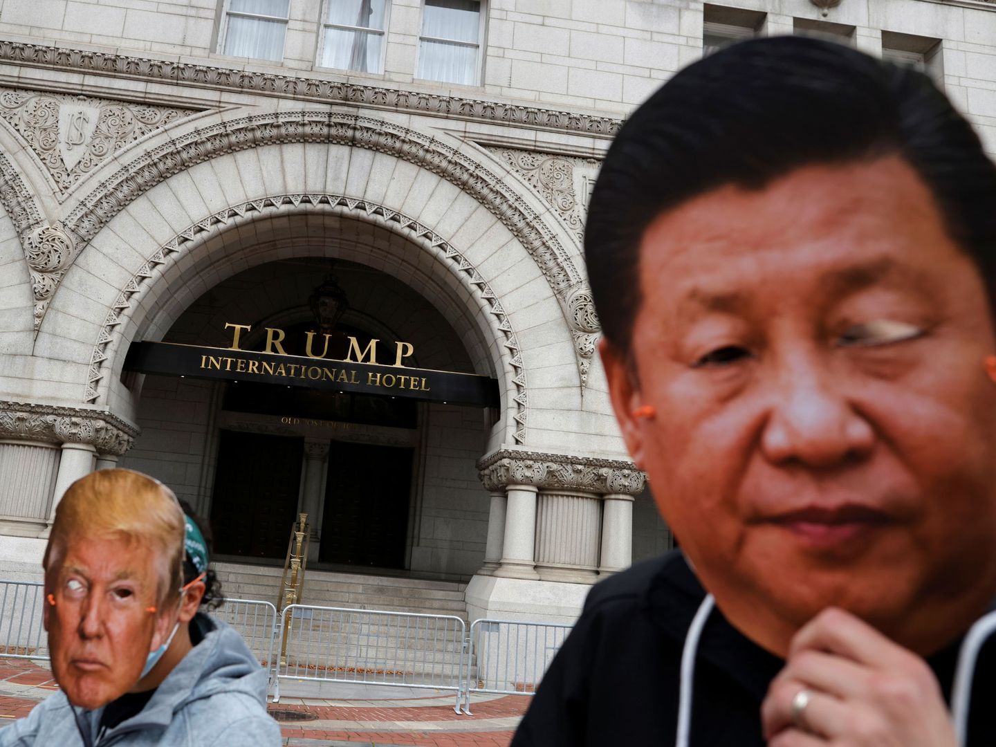 Manifestantes llevan caretas de Donald Trump y Xi Jinping ante un hotel propiedad del primero. (Reuters)