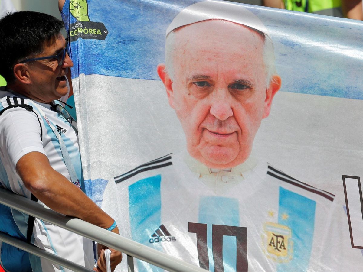 Foto: Un aficionado argentino muestra una pancarta con la imagen del papa Francisco luciendo la albiceleste. (EFE)