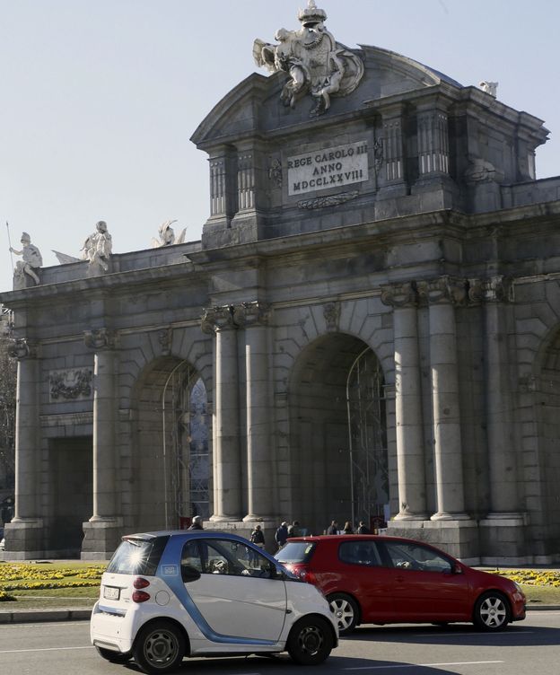 Foto: Un coche eléctrico a su paso por la Puerta de Alcalá. (EFE)