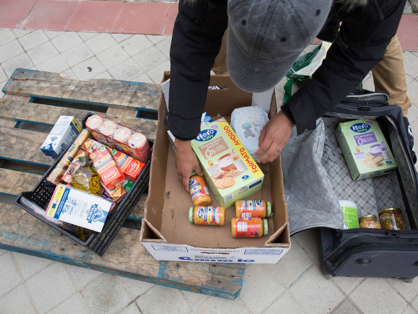 Un hombre llena una maleta con alimentos solidarios. (D.B.)